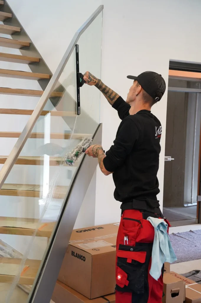 Glasgeländer einer Treppe wird gereinigt